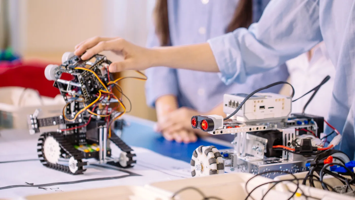 Varias manos trabajando juntas en un montaje de robótica