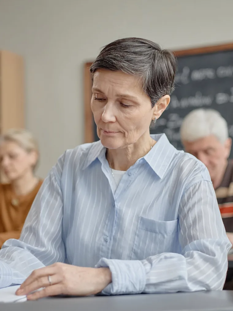 Mujer tomando apuntes en una clase para personas adultas